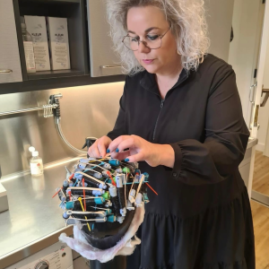 Haarwerkspecialist die krullen inzet bij een haarwerk